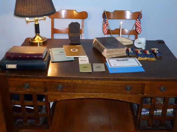 <b>Figure 1.</b> Desk, Bible, candle/flag holder, medals and other artifacts